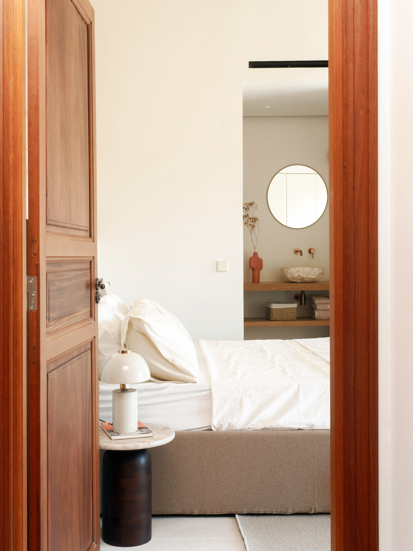 Bedroom with stone wall and white linens