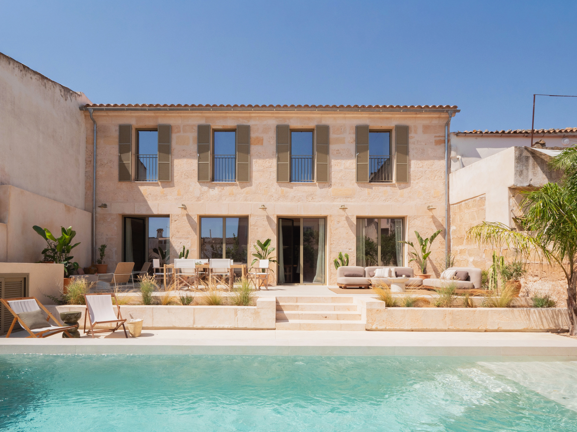 Stone façade of Casa Regal with pool and palm tree